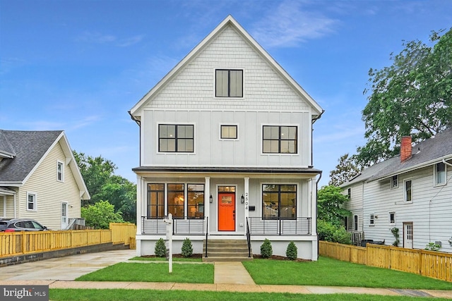 view of front of house featuring fence, a porch, board and batten siding, and a front yard