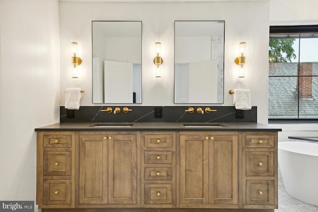 bathroom with a freestanding bath, double vanity, and a sink