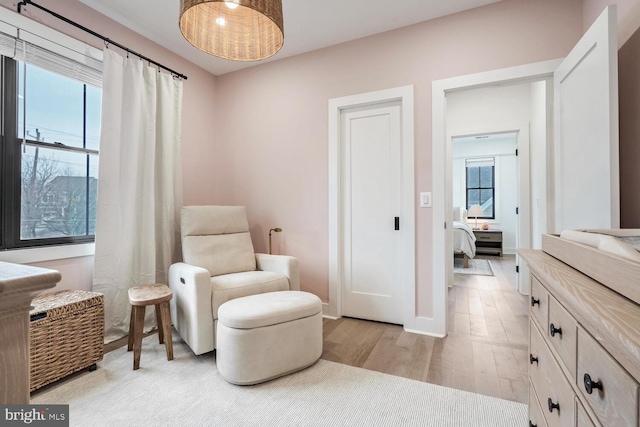 living area with light wood-style flooring and baseboards