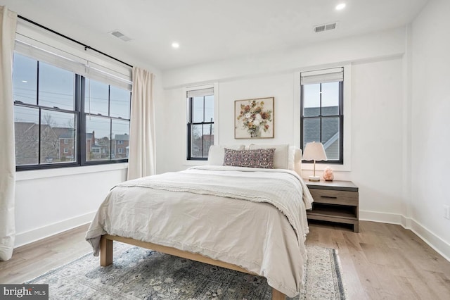 bedroom featuring wood finished floors, visible vents, and baseboards