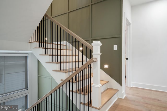 staircase featuring baseboards and wood finished floors