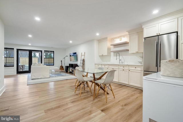 kitchen featuring light wood-style flooring, recessed lighting, a sink, french doors, and freestanding refrigerator