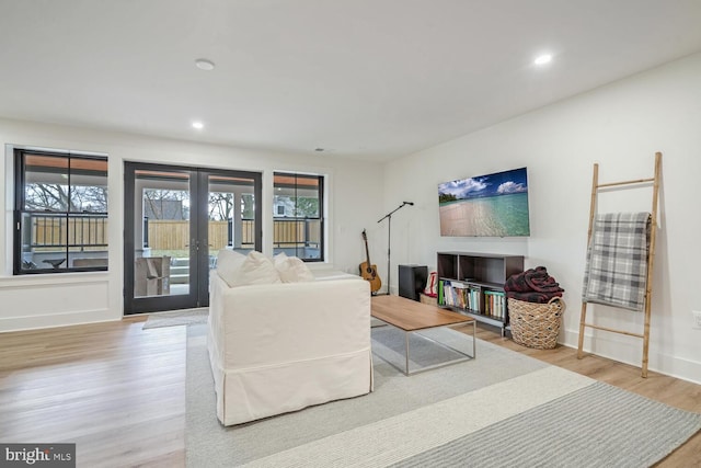 living area featuring recessed lighting, baseboards, wood finished floors, and french doors