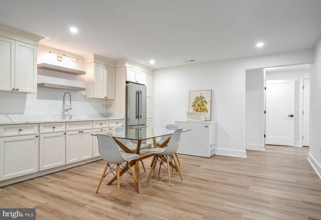 kitchen with light wood-style floors, high end fridge, a sink, and recessed lighting