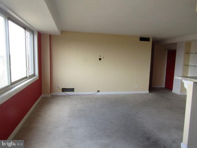 empty room featuring light carpet and baseboards