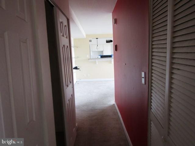 corridor with carpet and baseboards