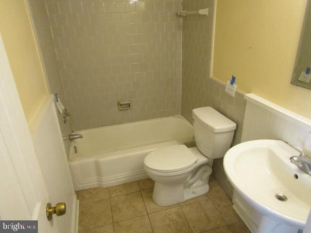 bathroom with a sink, bathing tub / shower combination, toilet, and tile patterned floors