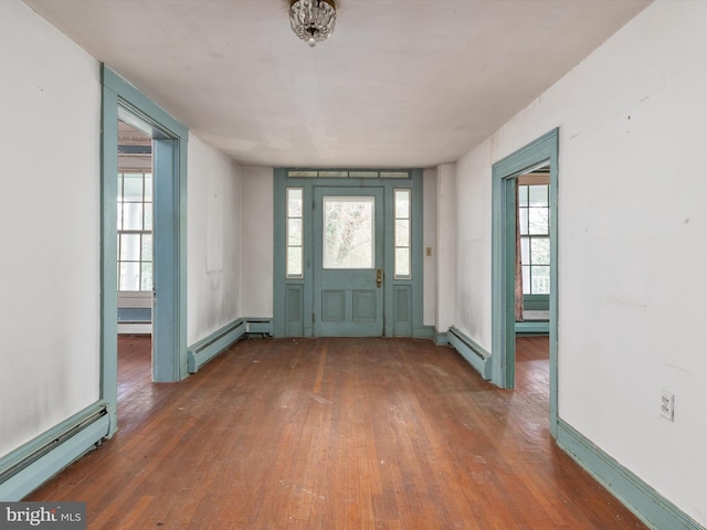 foyer with hardwood / wood-style floors and a baseboard heating unit