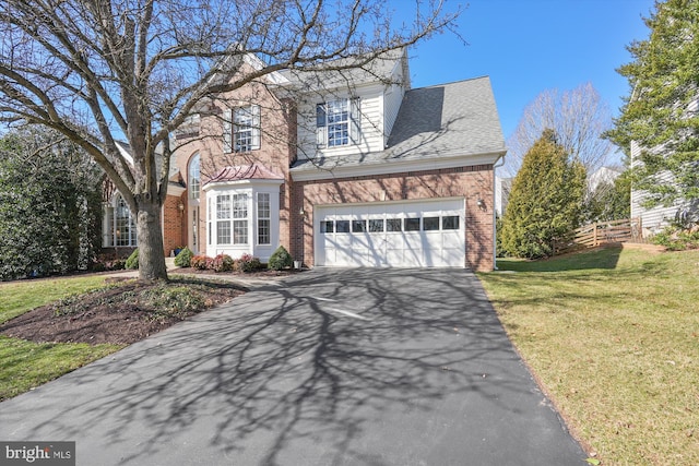 view of front of house with roof with shingles, an attached garage, a front lawn, aphalt driveway, and brick siding