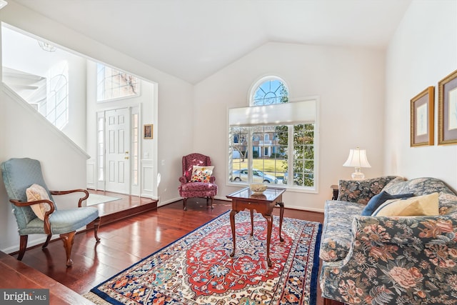 living area with vaulted ceiling, plenty of natural light, baseboards, and wood finished floors