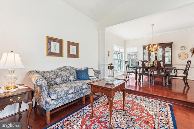 living area with vaulted ceiling, crown molding, wood finished floors, and a chandelier