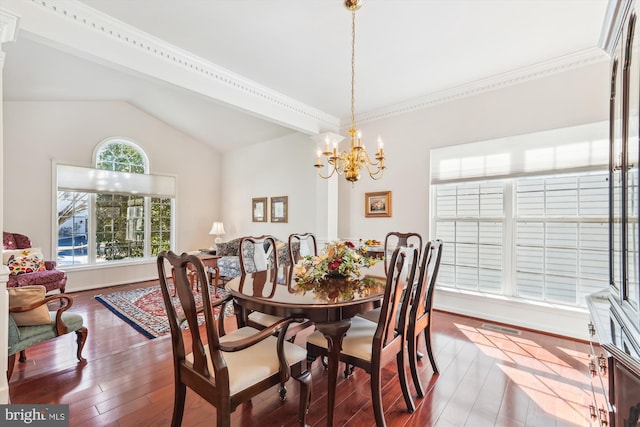 dining space featuring an inviting chandelier, vaulted ceiling, wood finished floors, and visible vents