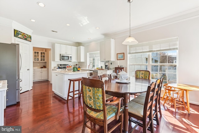 dining room featuring recessed lighting, crown molding, and dark wood-type flooring