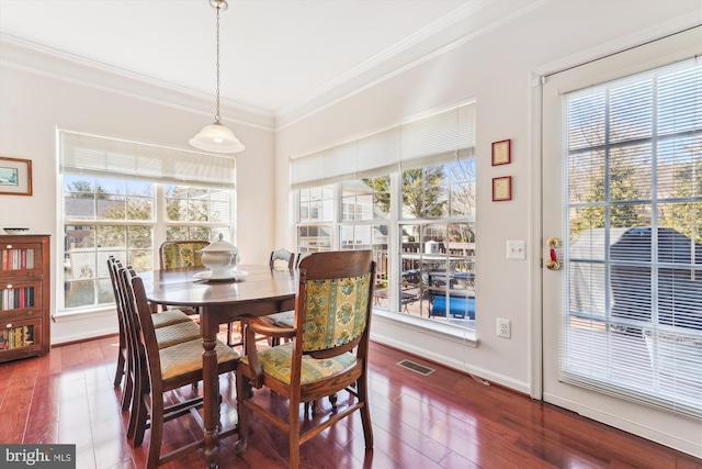 dining area featuring visible vents, baseboards, dark wood-type flooring, and ornamental molding