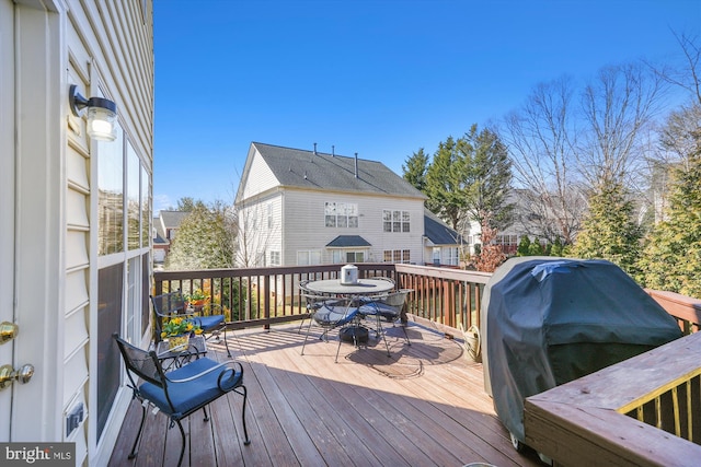 wooden terrace with outdoor dining area and area for grilling