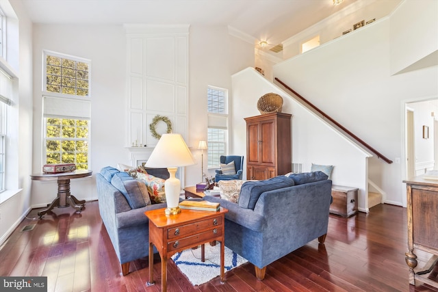 living room with stairway, a healthy amount of sunlight, and high vaulted ceiling