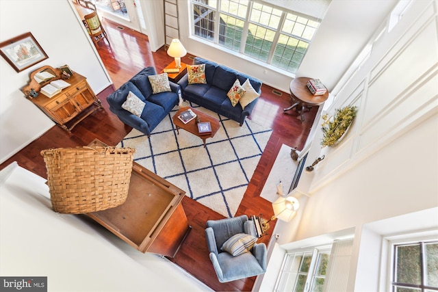 living room with a towering ceiling and wood finished floors