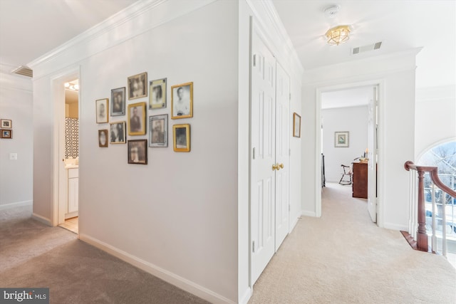 hallway featuring visible vents, light colored carpet, and ornamental molding