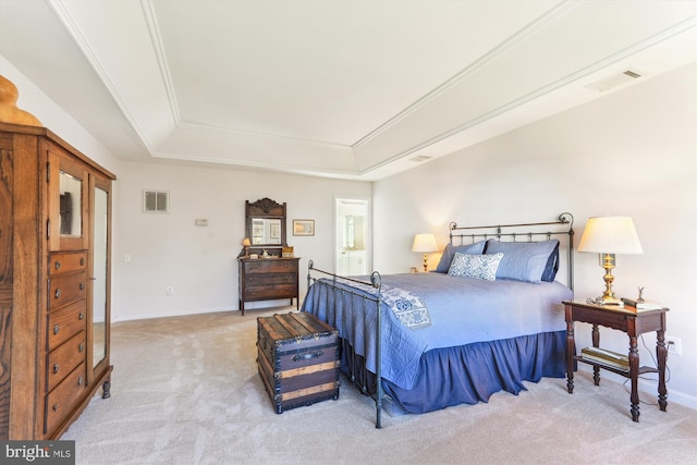 bedroom featuring light carpet, visible vents, and a tray ceiling