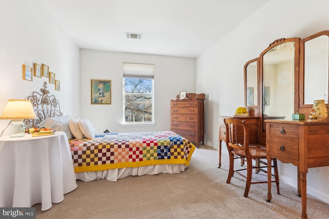 carpeted bedroom with visible vents and baseboards