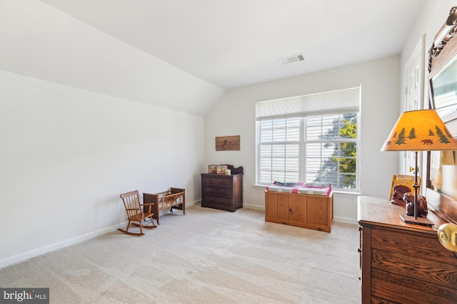 sitting room featuring light carpet, visible vents, baseboards, and vaulted ceiling