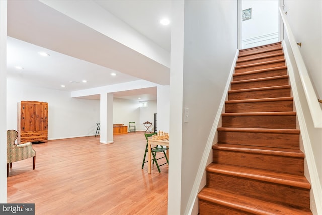 stairway with recessed lighting, baseboards, and wood finished floors