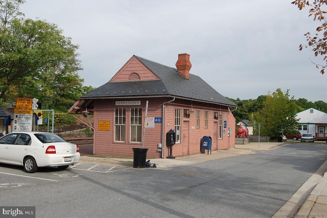 exterior space with uncovered parking and a chimney