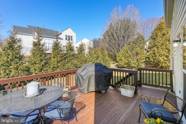 deck with outdoor dining space and a grill