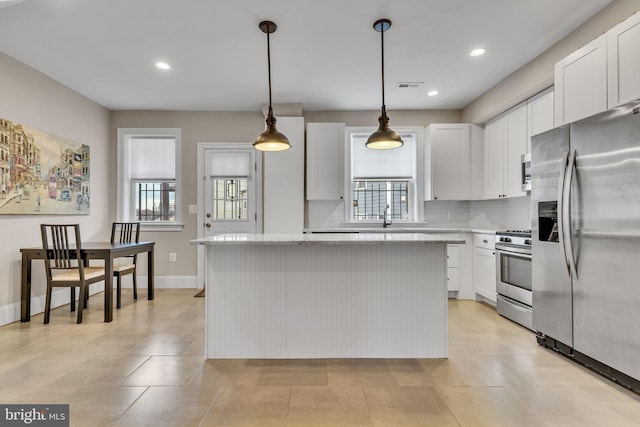 kitchen featuring visible vents, decorative backsplash, appliances with stainless steel finishes, white cabinetry, and a kitchen island