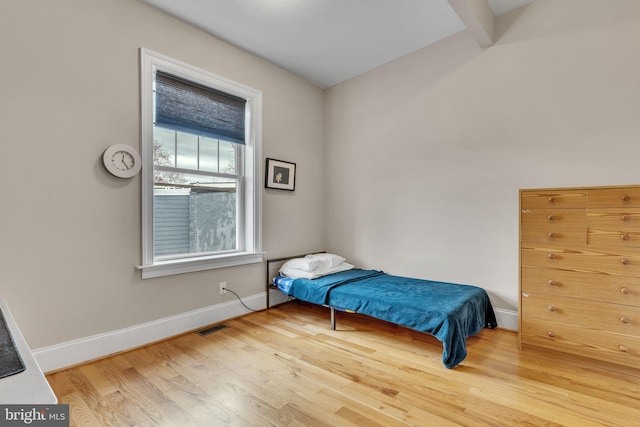 bedroom featuring visible vents, baseboards, and wood finished floors