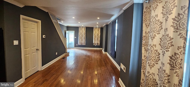 corridor with recessed lighting, visible vents, ornamental molding, wood finished floors, and baseboards