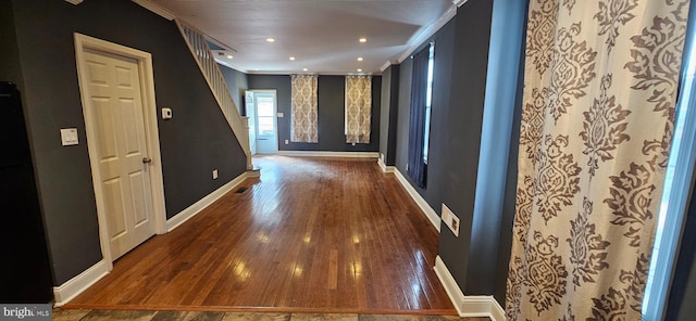 corridor featuring recessed lighting, wood-type flooring, crown molding, and baseboards