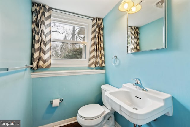 bathroom with toilet, a sink, and visible vents