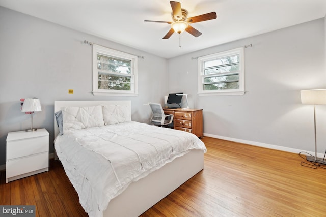 bedroom featuring wood finished floors, a ceiling fan, and baseboards