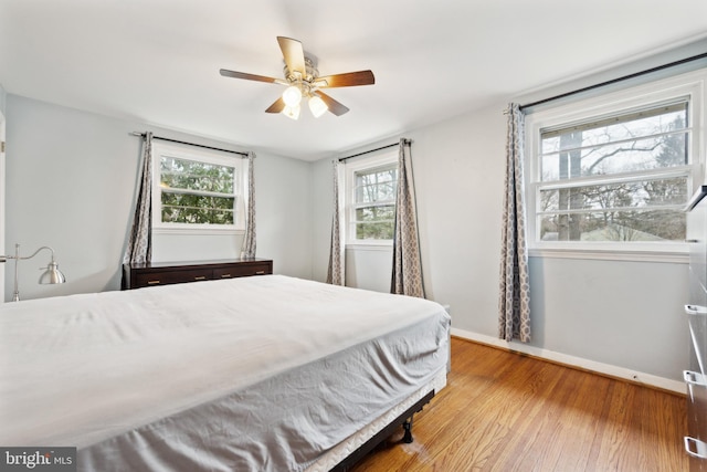 bedroom with a ceiling fan, baseboards, and wood finished floors