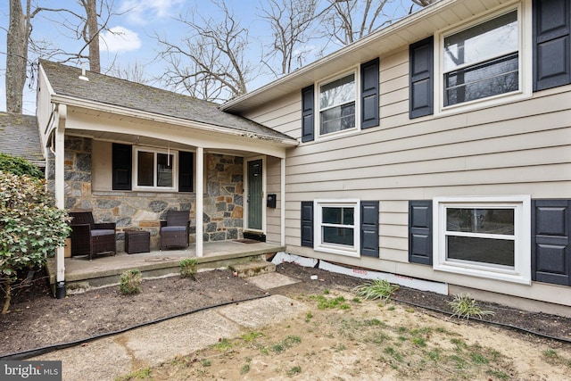 property entrance featuring stone siding and covered porch