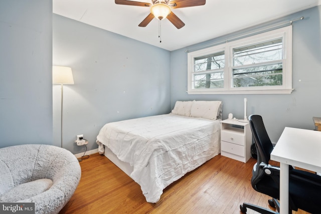 bedroom with light wood-type flooring, ceiling fan, and baseboards