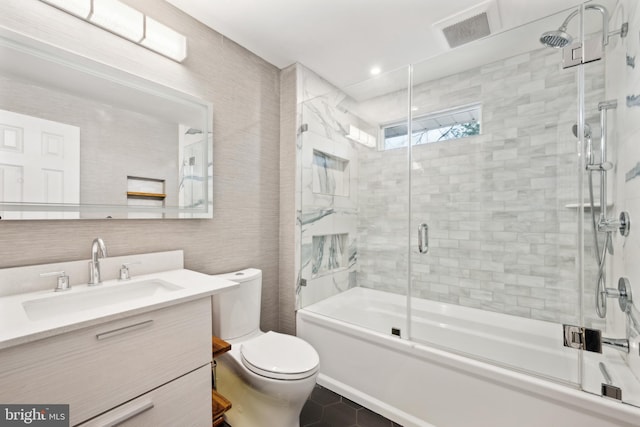 bathroom with toilet, shower / bath combination with glass door, vanity, visible vents, and tile patterned floors