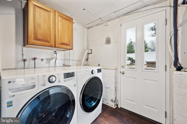 clothes washing area featuring dark wood-type flooring, cabinet space, and separate washer and dryer