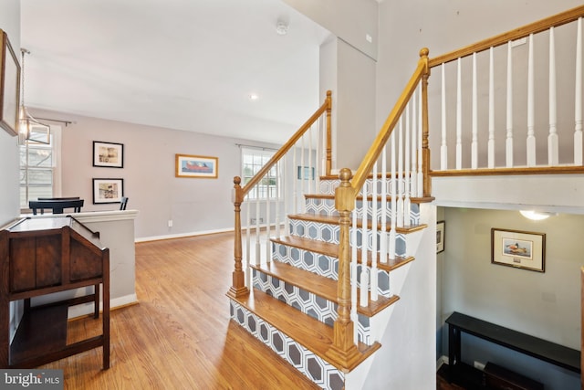 stairway featuring wood finished floors and baseboards