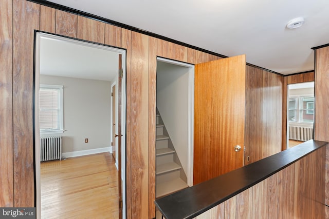 staircase with plenty of natural light, radiator heating unit, and wood finished floors