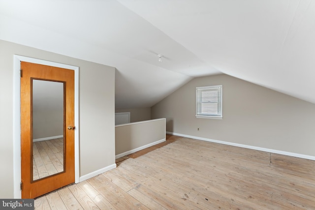 bonus room featuring vaulted ceiling, baseboards, and wood-type flooring