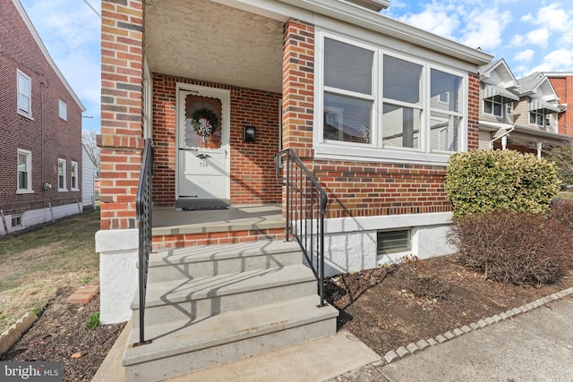 doorway to property with brick siding