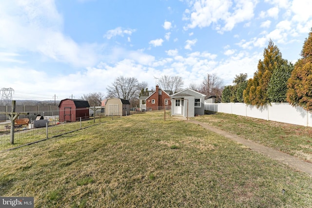 view of yard with an outbuilding, a fenced backyard, and a shed