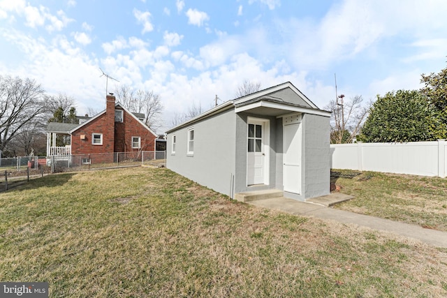 back of house featuring a fenced backyard and a yard