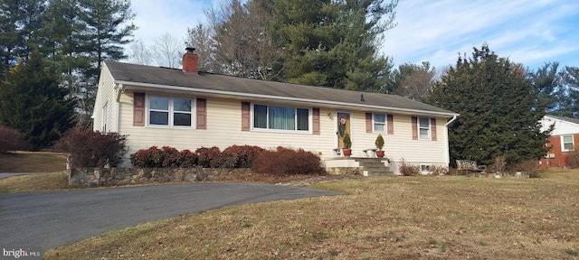 single story home featuring a front lawn and a chimney