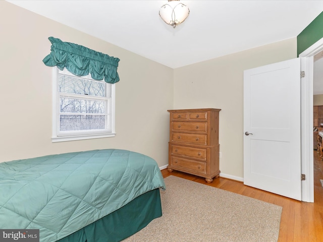 bedroom with baseboards and wood finished floors