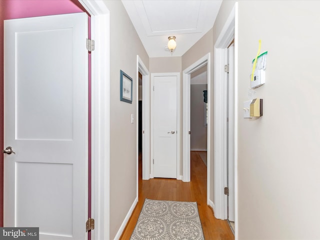 hall featuring wood finished floors and baseboards