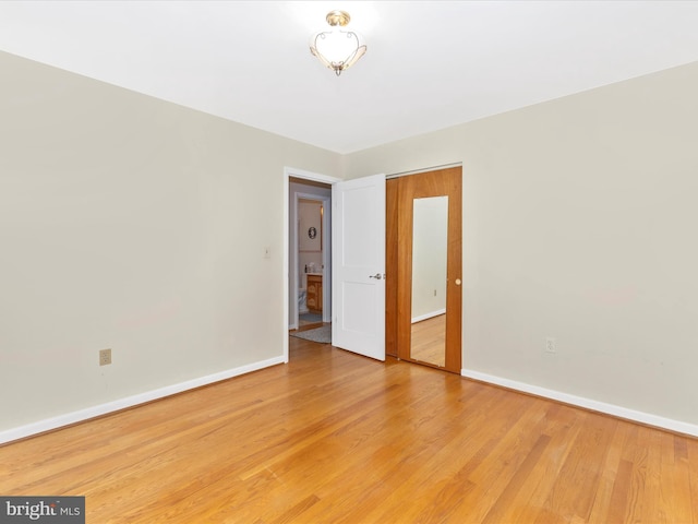 unfurnished room with baseboards and wood finished floors