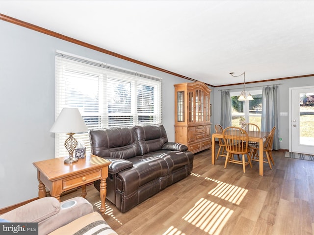 living area with ornamental molding, wood finished floors, and baseboards